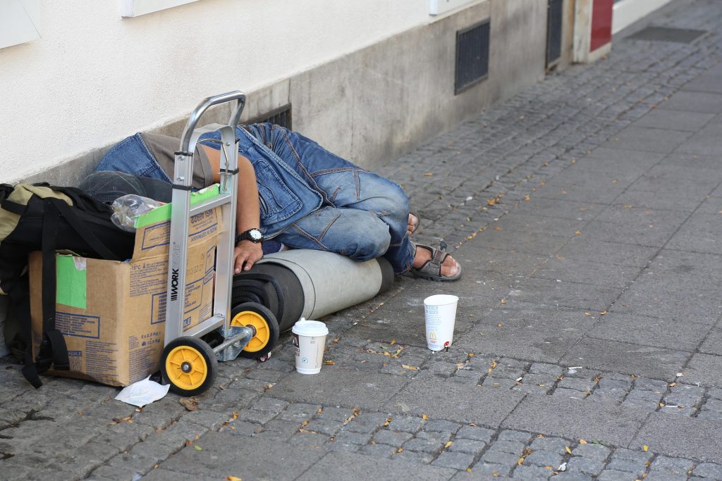 Homeless person sleeping on sidewalk